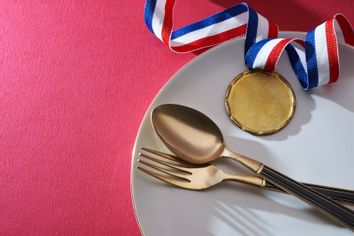 Gold medal on the dinner plate with fork and spoon